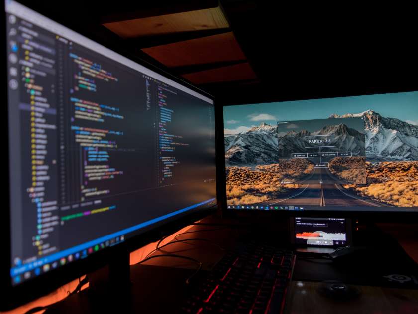 Two computer monitors showing code